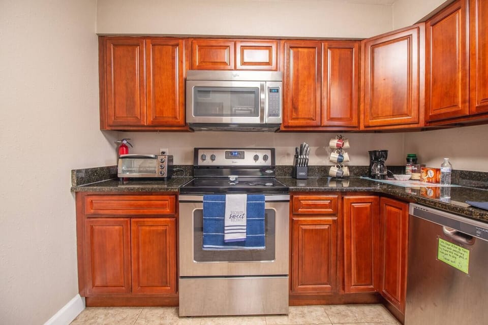 Kitchen, stove with oven, microwave, toaster oven, dishwasher, knife set, coffee maker, coffee cups, storage cabinets