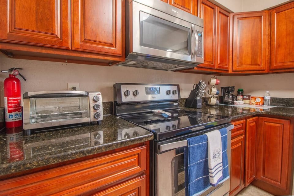 Kitchen, stove with oven, microwave, toaster oven, knife set, coffee maker, coffee cups, storage cabinets, fire extinguisher