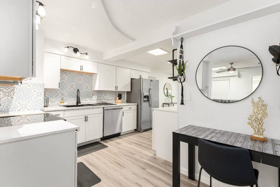 Modern and elegant kitchen with stainless steel appliances, marble countertops, and a cozy work nook