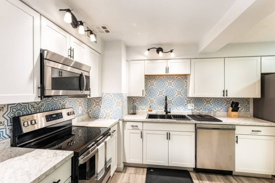 kitchen with cabinets, microwave, 4-burner stove with oven and large refrigerator