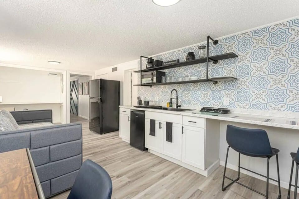 kitchen with cabinets, small two-place stove, fryer,refrigerator and slow cooker with microwave oven