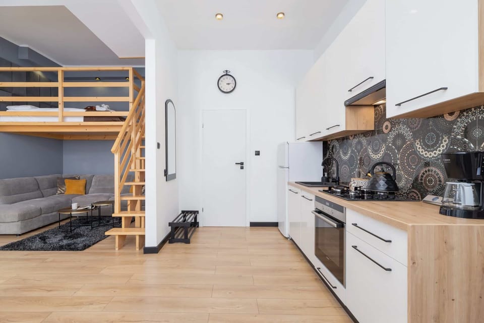 Another angle of the kitchen area, showcasing the clean, modern appliances and loft structure.
