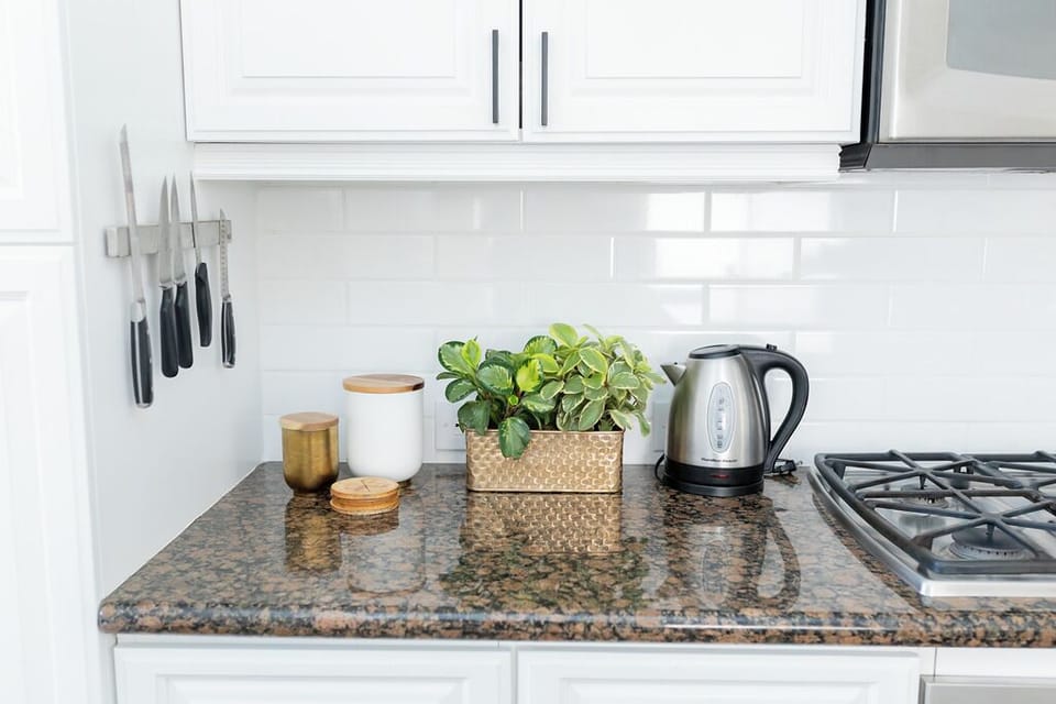 Stylish kitchen with marble island, seating for 4, and stainless appliances.