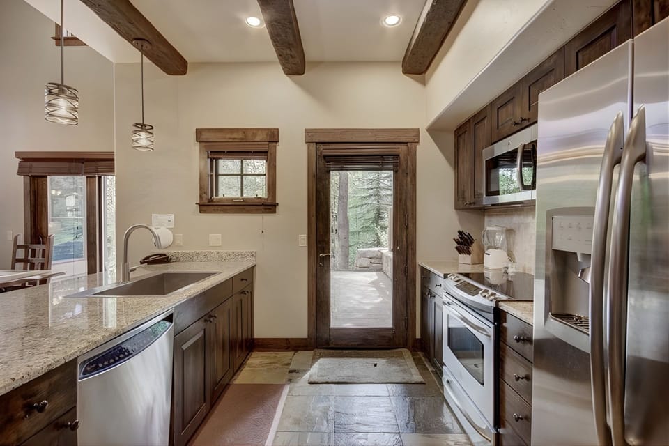 Bathed in natural light, this beautifully appointed kitchen blends alpine charm with contemporary design for an inspiring culinary experience.