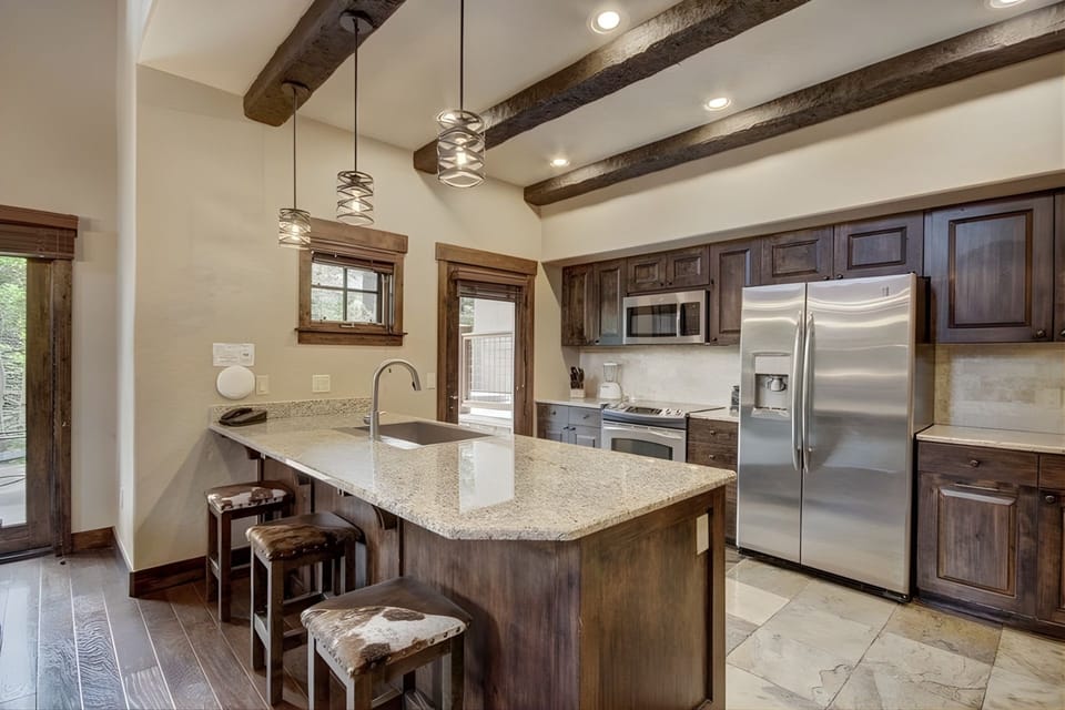 The heart of this mountain retreat, a gourmet kitchen of rich wood tones and modern touches, invites convivial gatherings and relaxed cooking alike.