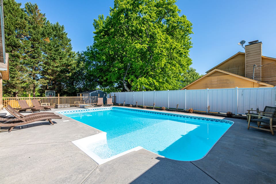 This West Knoxville home features a stunning backyard with private pool, diving board, hot tub, fire pit, outdoor dining, and basketball goal.