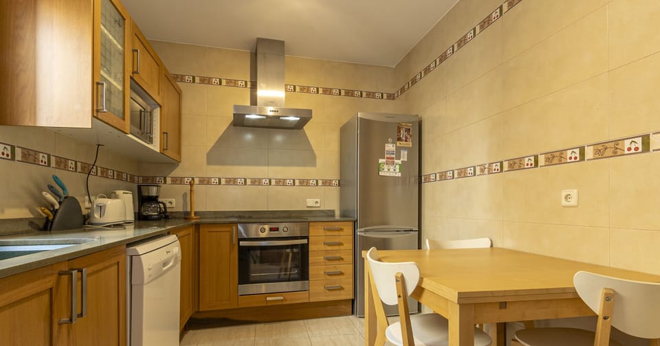 Spacious fully equipped kitchen with modern appliances and a comfortable dining area.
