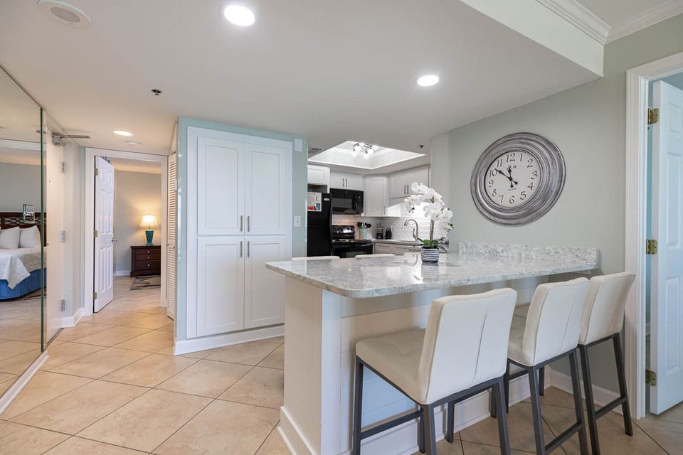 This bright kitchen features sleek white cabinetry, granite countertops, and a cozy breakfast nook for morning coffee