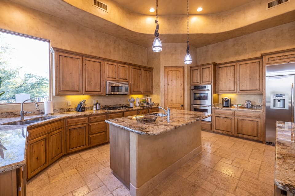 A spacious kitchen with island with top of the line stainless steel appliances