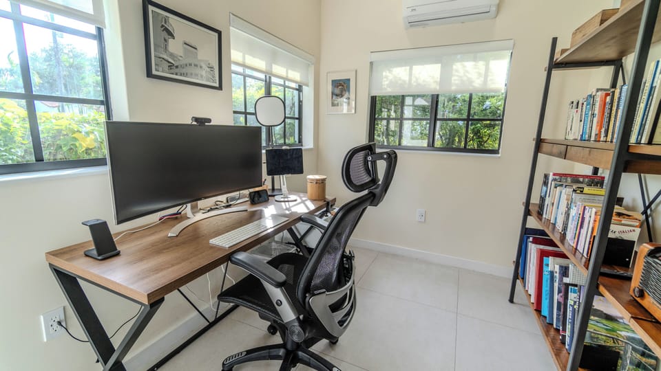 Quiet separate office with desk and color printer. 