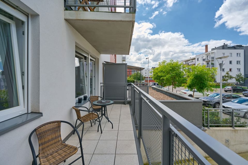 Spacious balcony with outdoor furniture. 