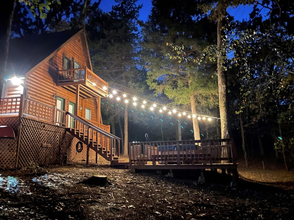 View at night with string lights over the hot tub