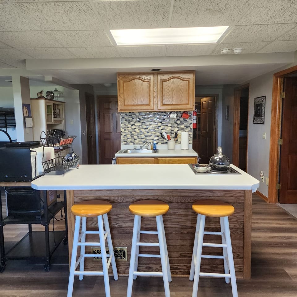 Kitchen area with snackbar, small refrigerator, microwave, toaster oven.