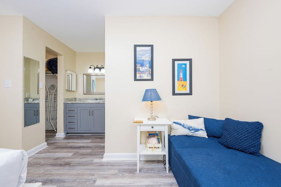 This cozy space in the master features a blue seating area, stylish decor, and a well-appointed bathroom with modern fixtures