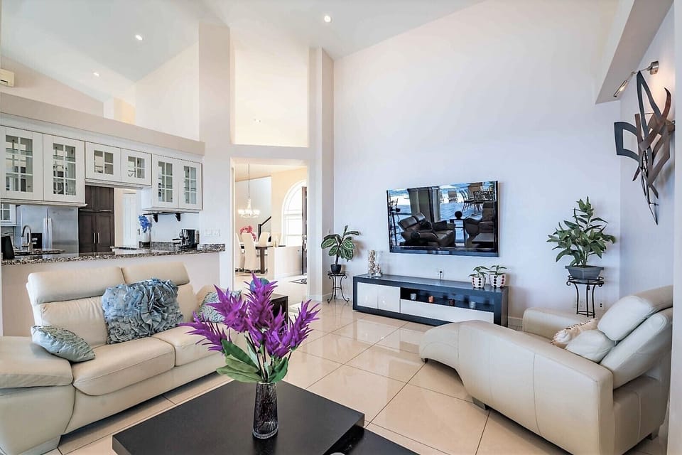 Livingroom with large 70" TV and sliding doors to the dining area on the porch