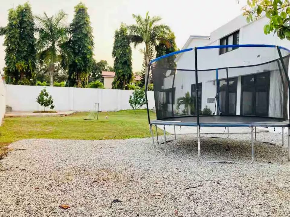 Backyard includes a trampoline and grassy area.