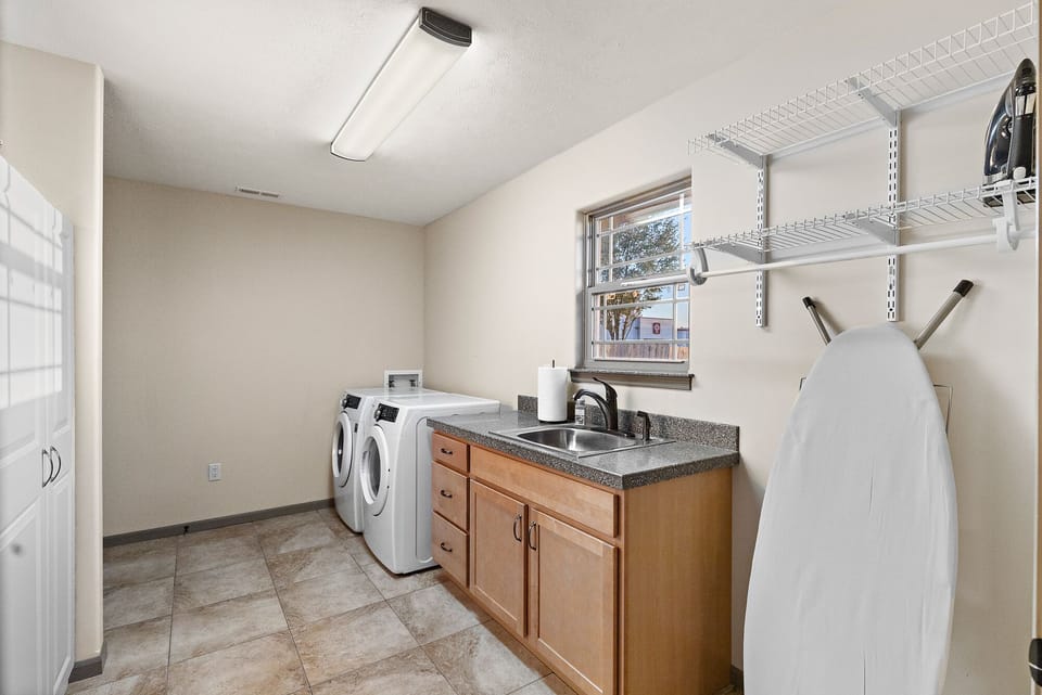 Laundry room with washer, dryer, iron, & ironing board