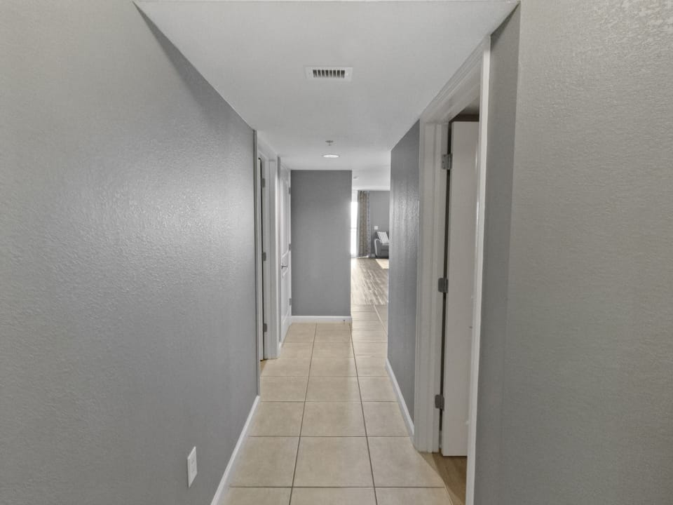 Step into your bright, welcoming hallway where modern tile floors guide you to spacious rooms throughout your home.