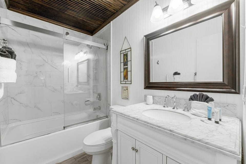 Downstairs full bathroom with tub and shower — convenient for guests and easy cleanup after beach days.