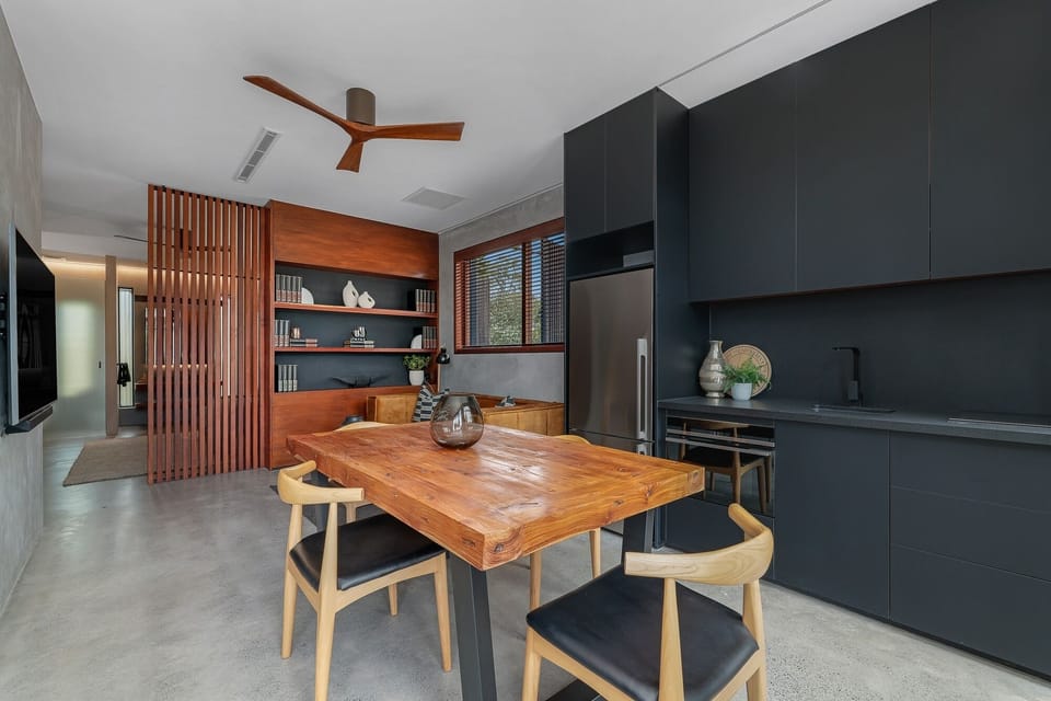 Separate dining and kitchen area in single space with dining table, chairs, TV