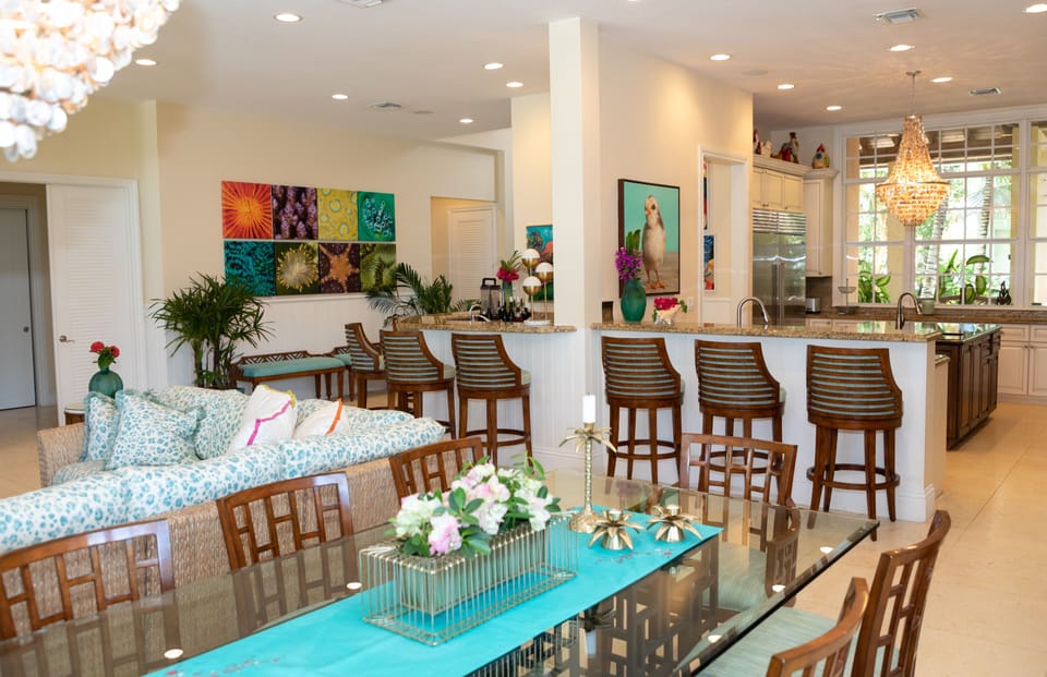 Main floor living space with view of the kitchen, dining table, and wet bar