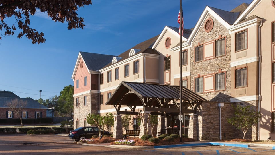 Step into a welcoming entrance adorned with charming stone accents and vibrant landscaping.