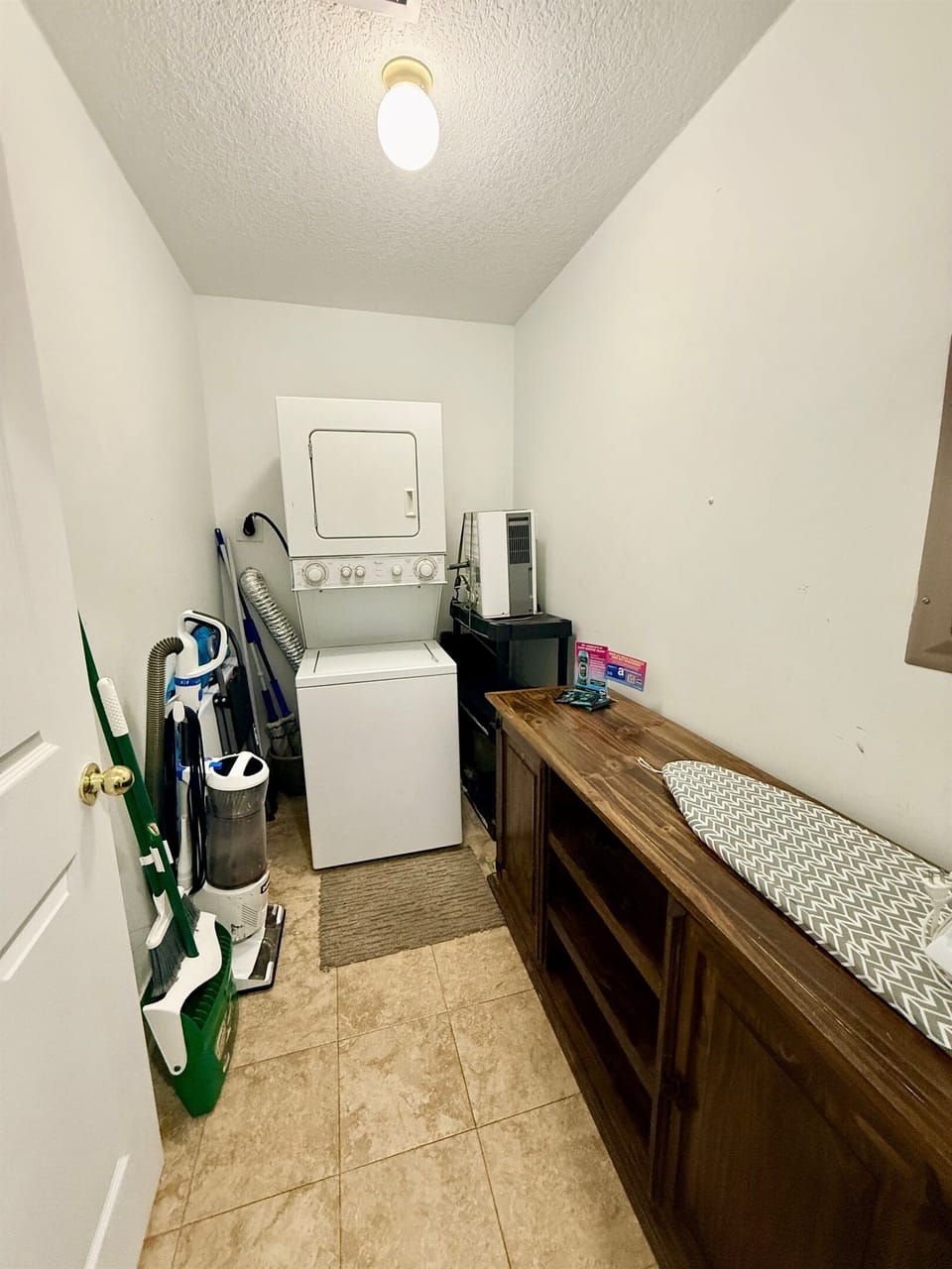 Large laundry room with a stacked washer & dryer, iron and storage for anything you might need!