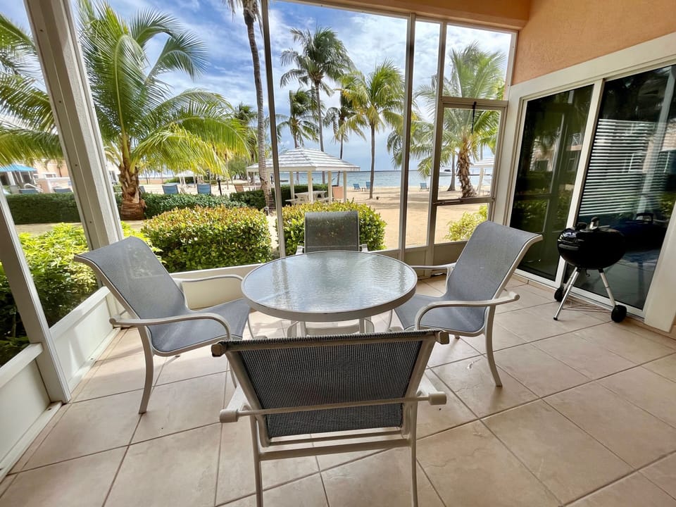 Privately screened outdoor patio seating area is only steps away from the beach!