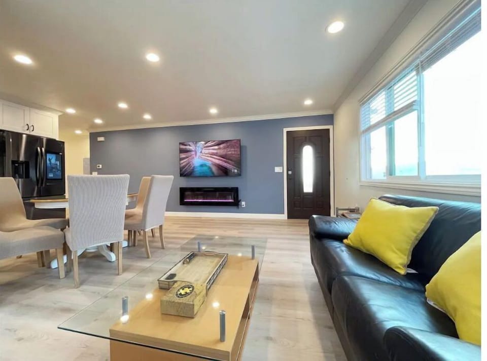 Living room with a 70" Smart TV with Netflix, 2 leather sofas and 3 big windows