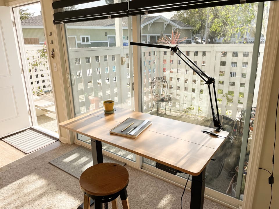 working area. Includes rising desk, lamp, notebook, and writing utensils.