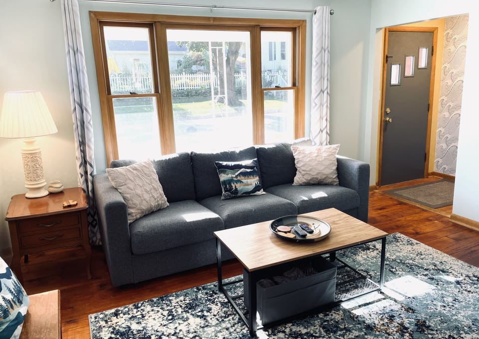Large picture window overlooks the front porch on a quiet residential street