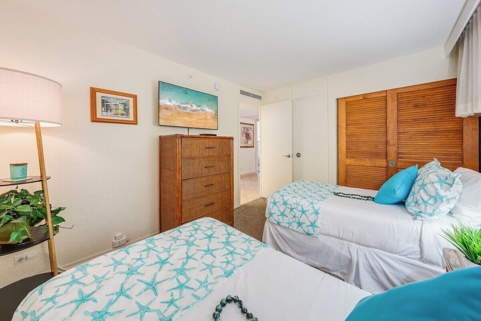 Bright guest bedroom with convertible twin beds that transform into a king, highlighted by fresh ocean‑inspired décor—perfect for families or friends