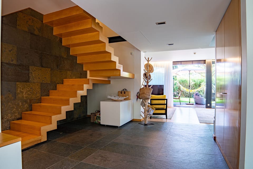 Modern staircase with wooden steps and stone feature wall — Home Six Troia, holiday villa in Grândola