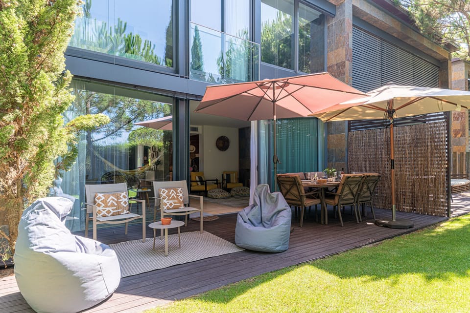 Spacious outdoor terrace with umbrellas and seating — Home Six Troia, holiday villa in Grândola