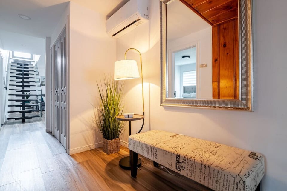 Hallway (Main Floor): Cozy bench seating with a side table creating a charming reading nook, plus a nearby closet stocked with an iron, ironing board, hangers, and extra storage for everyday ease