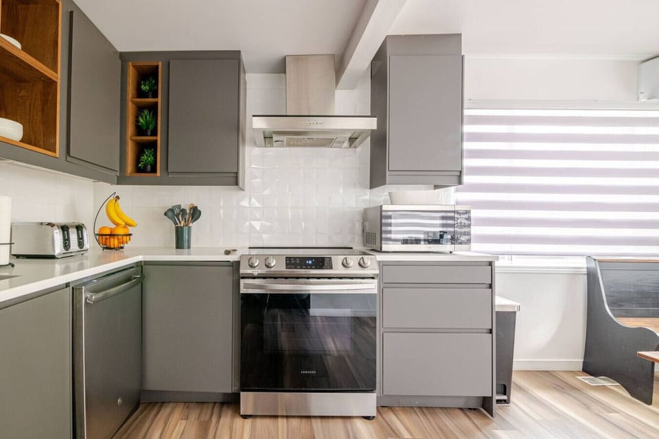 Kitchen (Main Floor): Bright kitchen with natural light, featuring a convection oven, ceramic cooktop with exhaust fan, and a countertop microwave for added convenience
