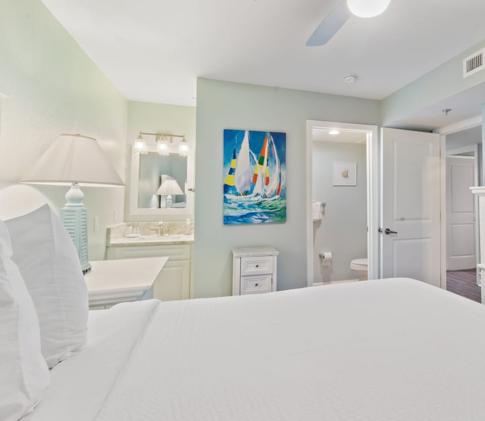 Drift off peacefully in your bright, airy bedroom with serene coastal colors and ensuite bathroom convenience.