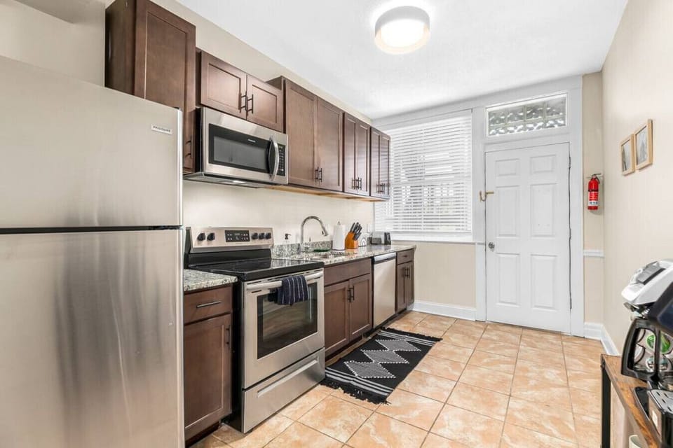 Large kitchen with cooking essentials, blender, and coffee cart.