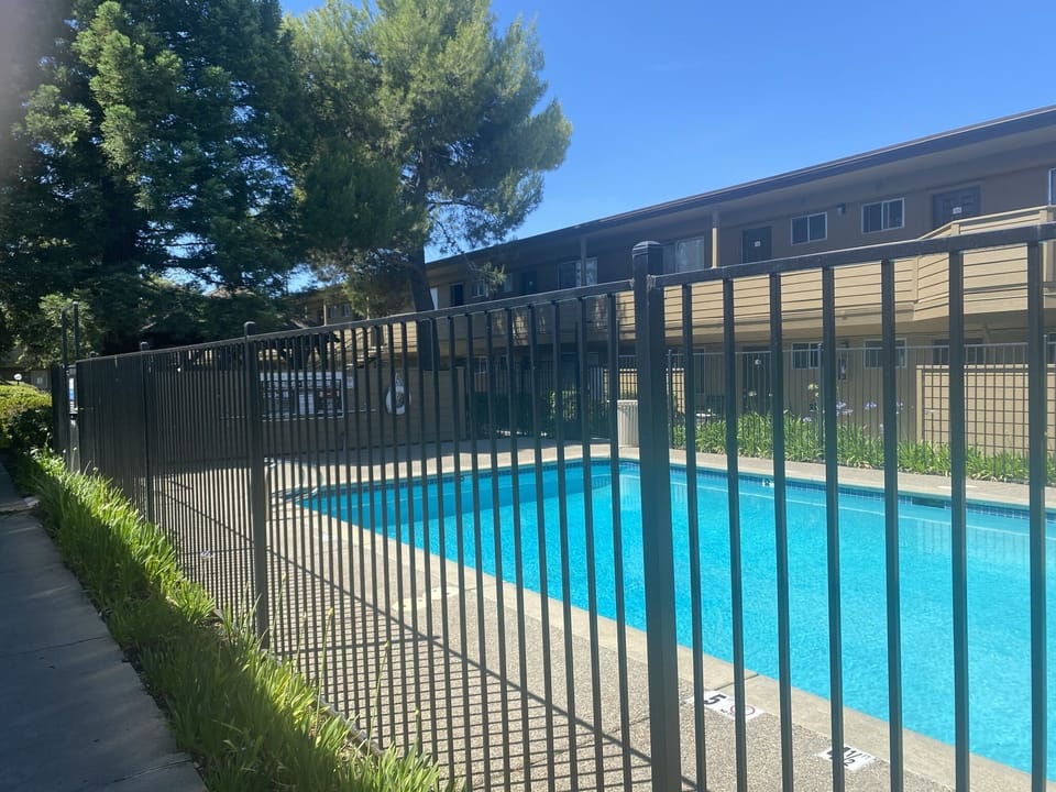 Walkway along poolside fence facing unit. In front of office, vending+laundry.