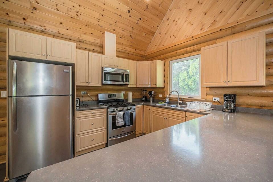 A fully equipped kitchen with modern amenities awaits in the kitchen, where guests can cook and converse in a space that feels like home.