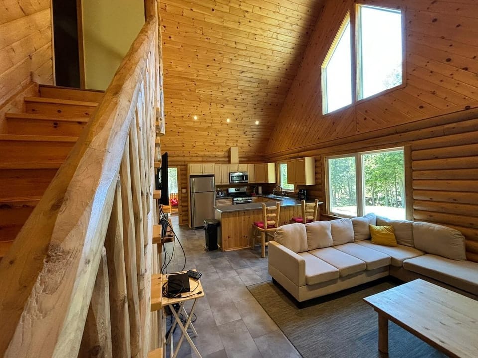 The Great room with easy access to the upper sleeping area and lower kitchen with eating island. The main staircase leads to an upper main bathroom and two bedrooms. The kids love yelling from the upper landing in the morning! 