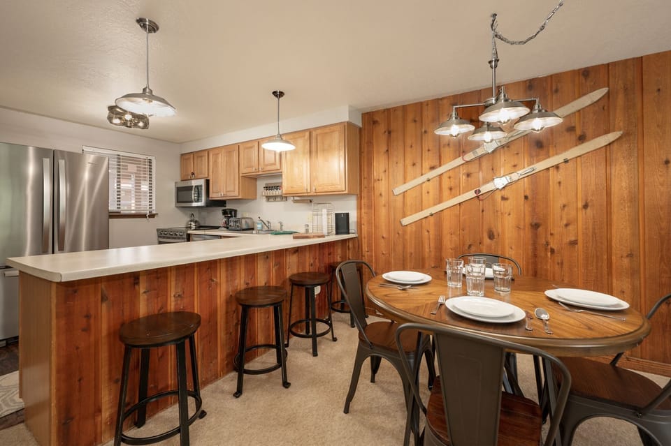 Your rustic kitchen blends warm wood with modern steel appliances. Enjoy meals at the round table or gather at the breakfast bar.