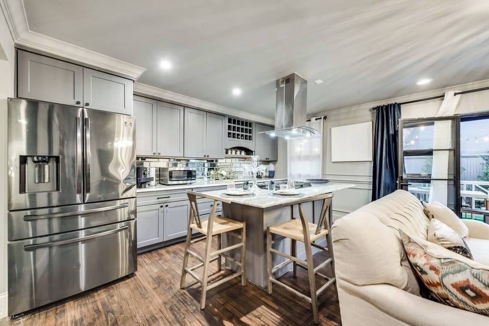 A fully equipped gourmet kitchen with a gas range, stainless steel vent hood, and all the essentials, perfect for entertaining.
