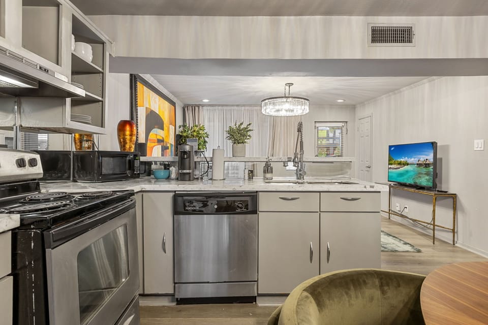 Modern kitchen with dishwasher, full-size fridge, and sleek finishes