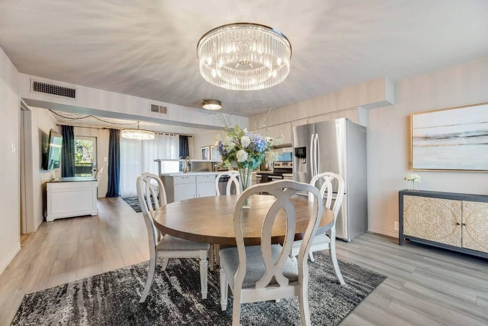 Open dining area with seating for four, featuring a beautiful chandelier..