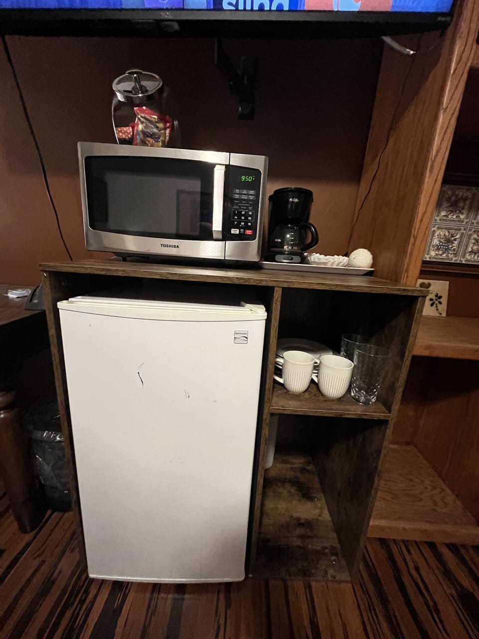 Mini fridge, microwave, coffee and coffee maker.