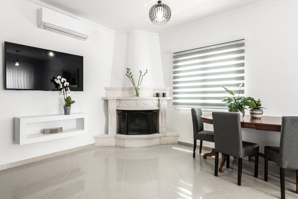 The living room area has an open fireplace and opens to a balcony. 