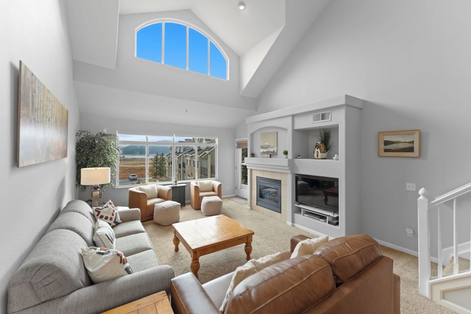 Relax in your spacious living room with soaring ceilings, cozy fireplace, and stunning lake views through expansive windows.