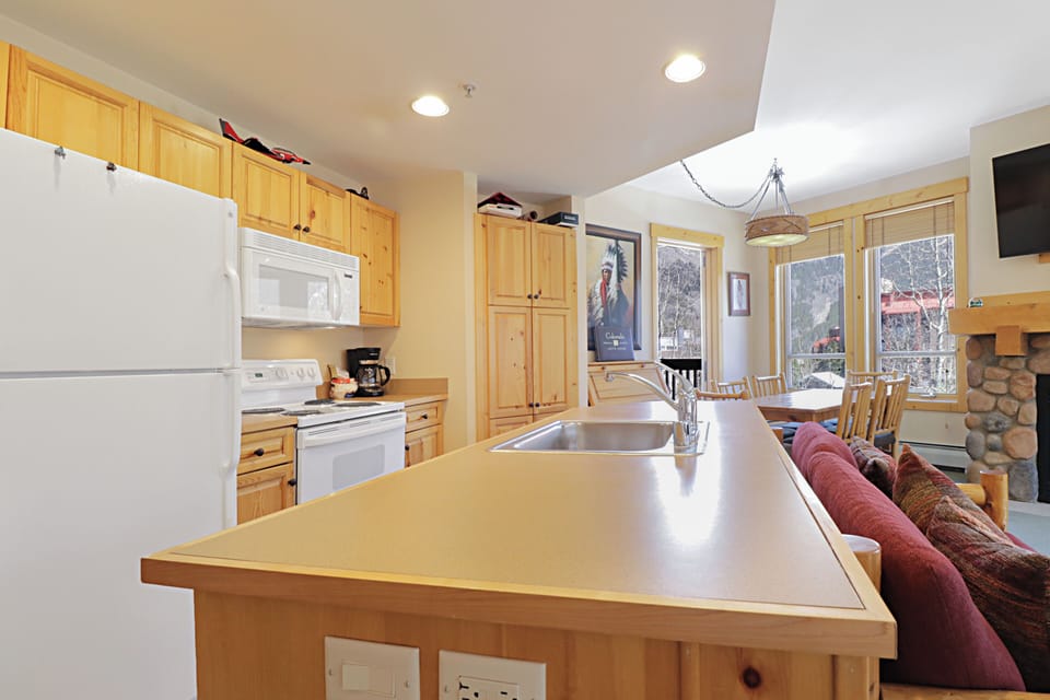 Your fully equipped kitchen island beckons with warm wood cabinets and modern appliances, perfect for preparing meals together.