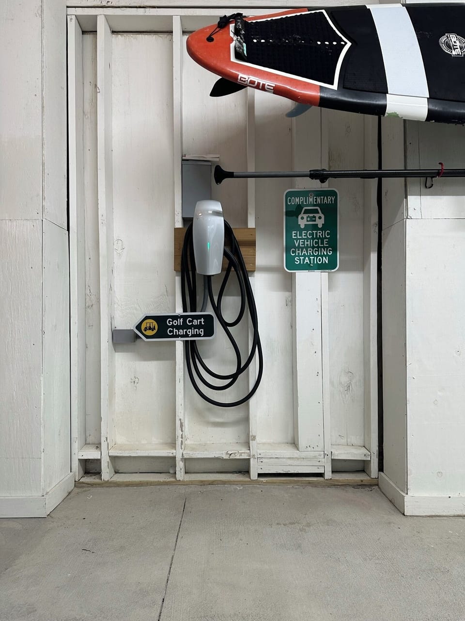 Garage with Tesla charger and beach gear storage.